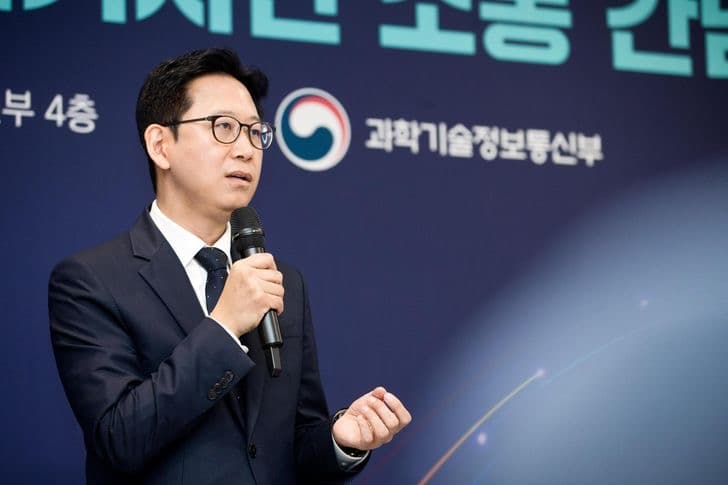 Science and ICT Minister Bae Kyung-hoon speaking into a handheld microphone at a ministry briefing